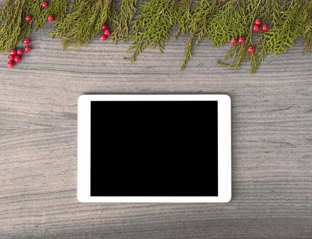 tablet display on table with isolated white screen for mockup in Christmas time