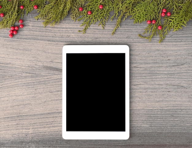 Tablet display on table with isolated white screen for mockup in christmas time