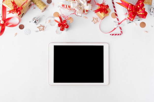 планшетный дисплей на столе с изолированным белым экраном для макета в Рождество