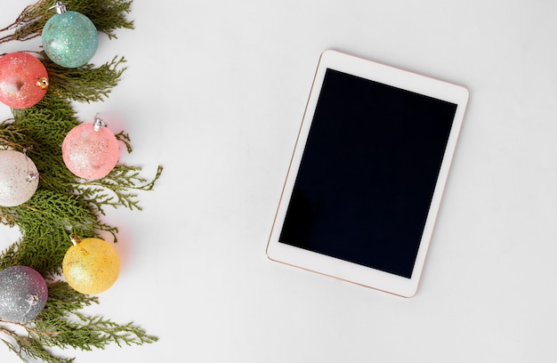 Tablet display on table with isolated white screen for mockup in Christmas time.