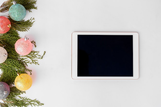 Tablet display on table with isolated white screen for mockup in Christmas time. 