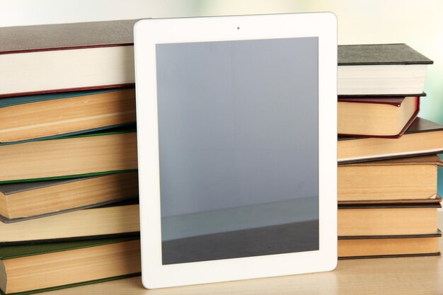 Tablet en boeken op lichte achtergrond