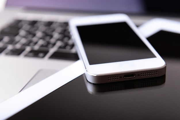 Tablet en mobiele telefoon op toetsenbord close-up