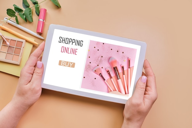 Tablet in female hands with open web page of cosmetics store