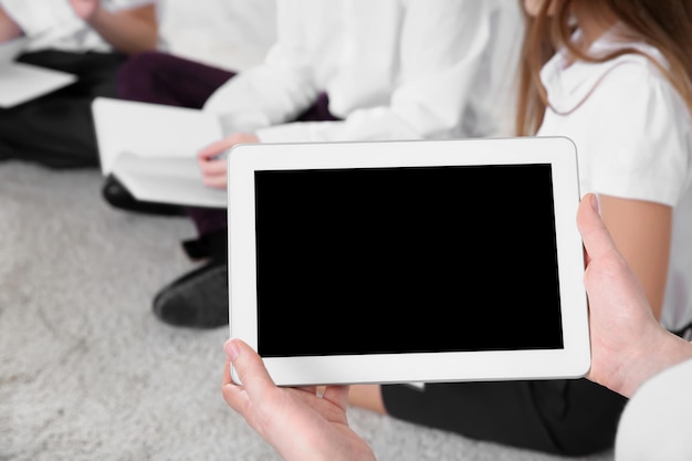 Foto tablet nelle mani dell'insegnante mentre conduce la lezione a scuola