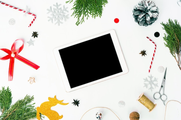 Foto tablet geïsoleerd voor kerstmis stijlvolle mock-up, kegels en sparrentakjes op witte achtergrond,