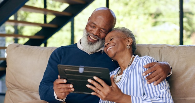 Tablet hug and senior couple on a sofa for web communication network or chat at home Digital app and old people embrace in living room with love social media or streaming subscription in a house