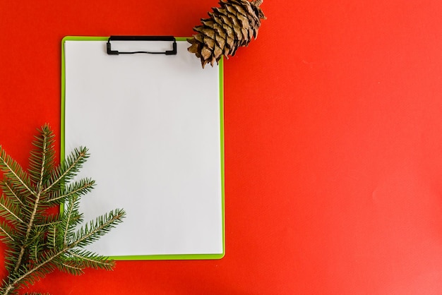 Tablet met een blanco vel op een rode kerstachtergrond