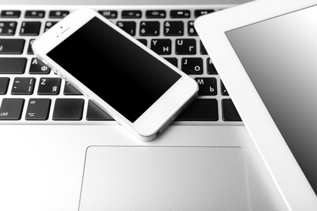 Tablet and mobile phone on keyboard closeup