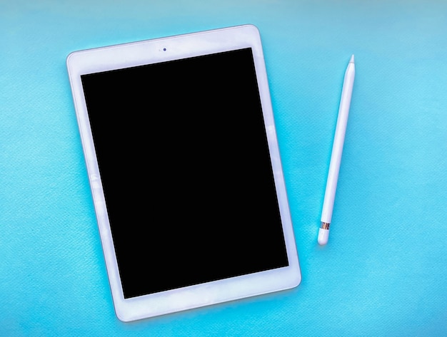 Foto tablet mock up sul tavolo con stilo isolato su sfondo blu. concetto di affari.
