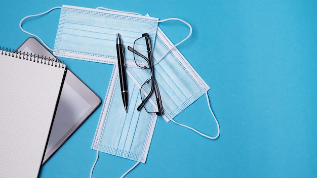 Tablet pc with face mask on blue background