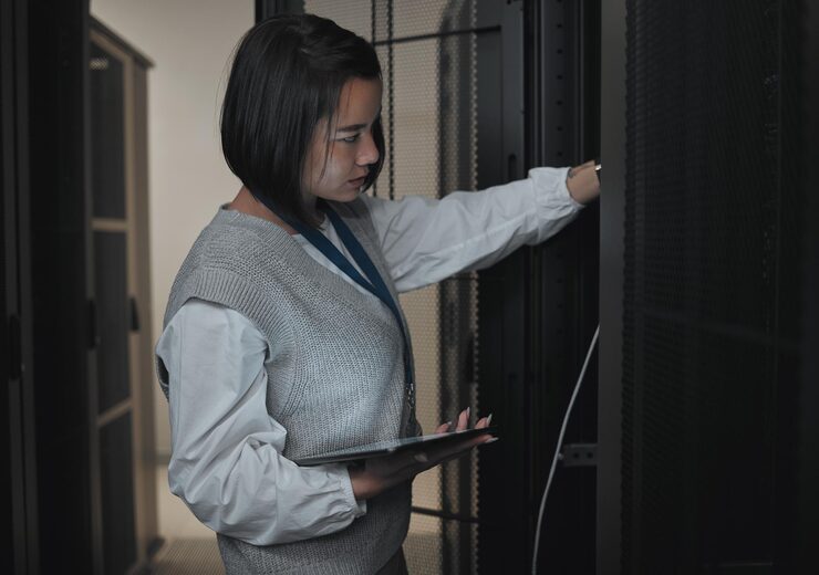 Photo tablet server room and engineering with a programmer asian woman at work on a computer mainframe software database and information technology with a female coder working alone on a cyber network
