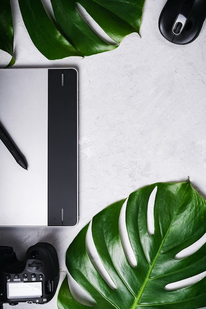 Tablet, stylus, camera, optical wireless mouse, monstera green leaf.