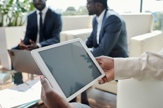 Tablet con schermo nero nelle mani di una giovane imprenditrice afroamericana