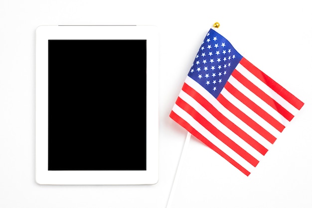 Foto tablet con schermo vuoto accanto alla bandiera americana