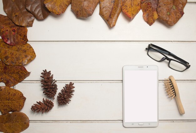 Tablet with empty screen for your text or image, comb and eyeglasses on wooden background. top view