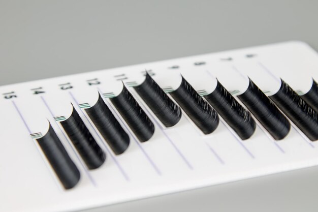 A tablet with false eyelashes on a gray background. Cosmetic accessories for eyelash extensions