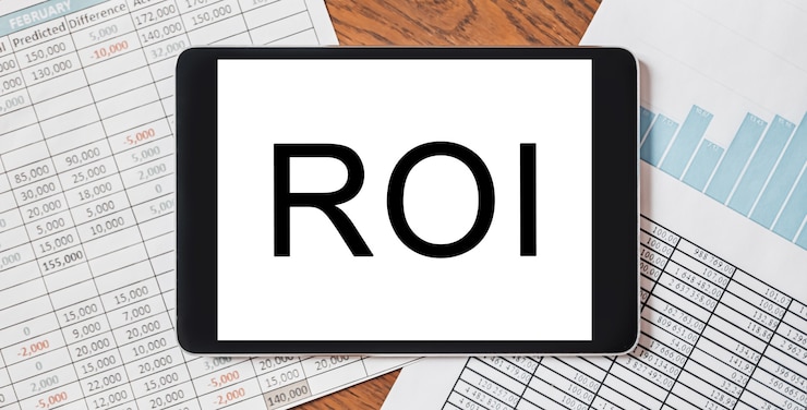 Photo tablet with text roi on your desktop with documents, reports and graphs. business and finance concept