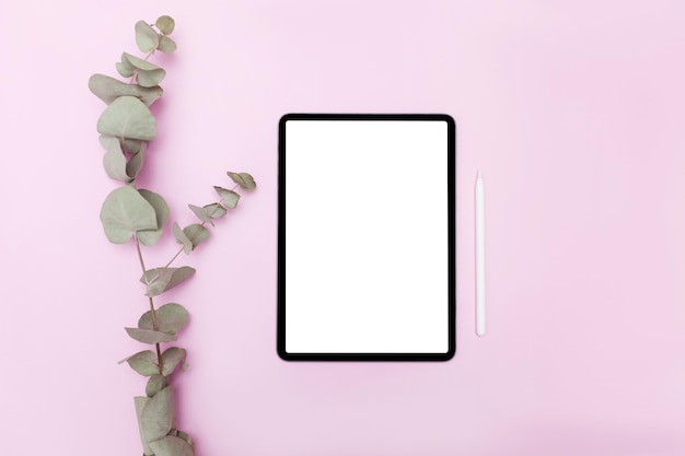 ピンク色の背景に白い画面とタブレット。 Flatlay。テーブルにカラーパレット付き