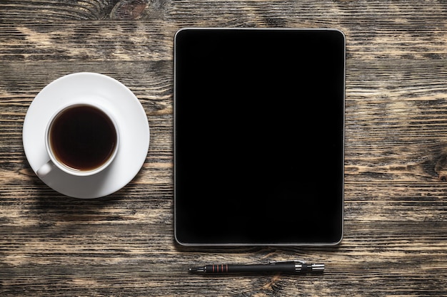 Tabletcomputer met koffie op houten tafel