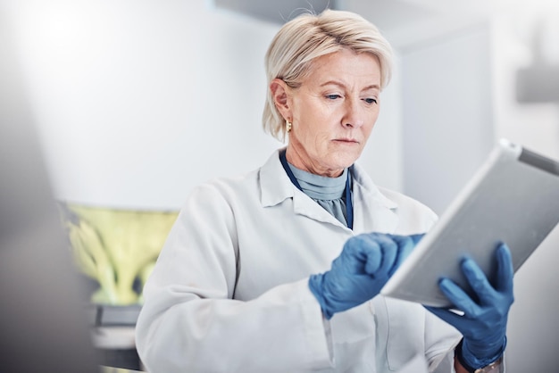 Tabletdenken en wetenschap met een doktersvrouw aan het werk in een laboratorium voor onderzoek, innovatie of ontwikkeling Medische gezondheidszorg en idee met een senior vrouwelijke wetenschapper die in een laboratorium werkt