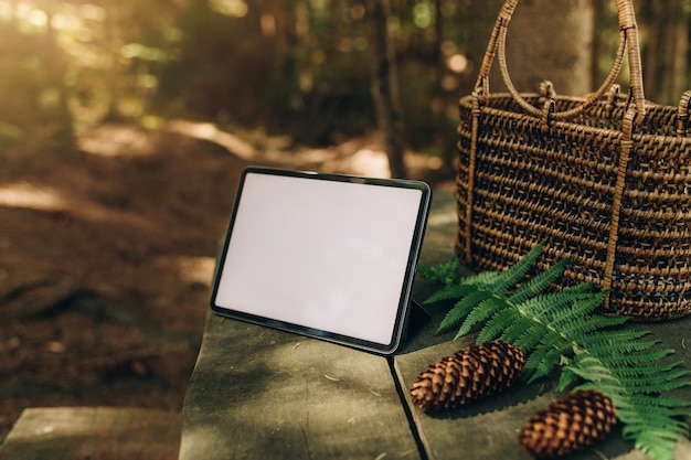Tabletmodel op de achtergrond van de natuur in het bos. Werkplek in de natuur, ipad-mockup met blanco