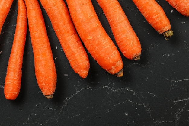 Vista da tavolo, carota cruda su tavola di pietra nera