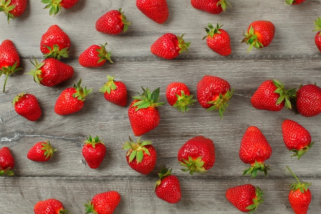 Tabletop view - ripe strawberries, freshly picked, on gray wooden boards.