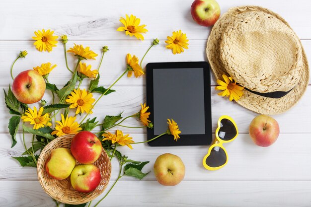 Tabletpc met rustieke toebehoren op lichte houten achtergrond.