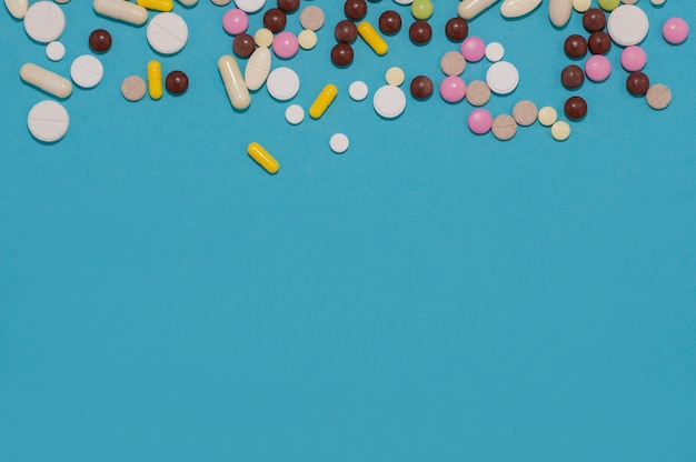 Photo tablets and capsules of different colors on a blue background