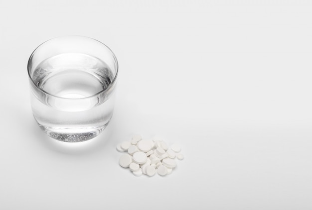 Tablets and pills and glass of water