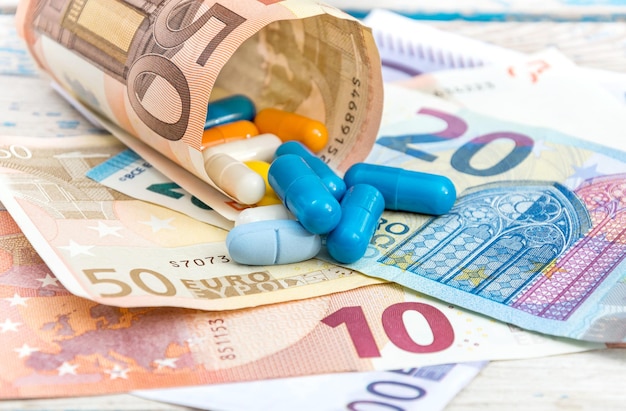 The tablets wrapped in euro with euro banknotes on the table Medical concept