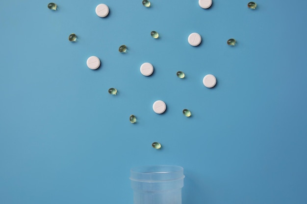 Tabletten en capsule op een blauwe achtergrond