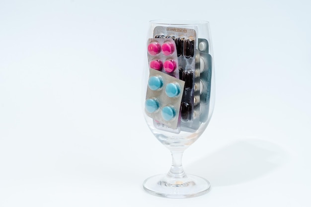 Tabletten en medische capsules in een blisterverpakking in glas geïsoleerd op een witte achtergrond
