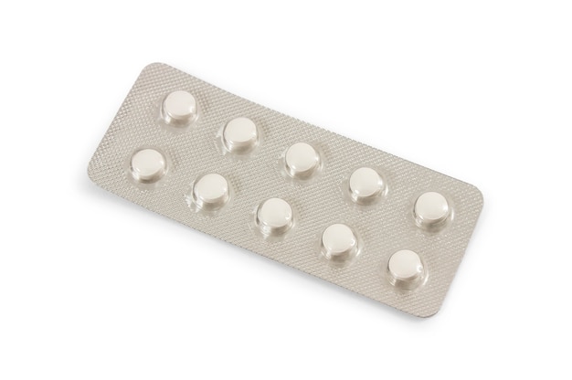 Tabletten in een pakket dat op wit wordt geïsoleerd