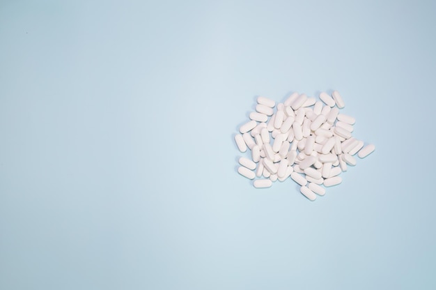 Tabletten, vitamines en voedingssupplementen op een blauwe achtergrond.