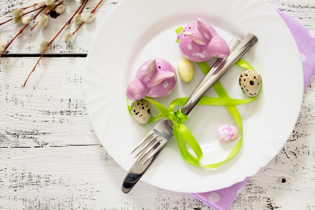 Tableware day Happy Easter - plate, knife, fork, top view.