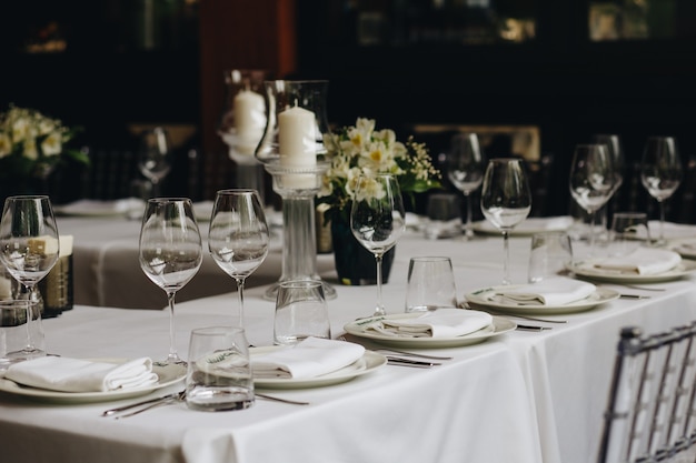 Tableware Glasses, flower fork, knife served for dinner in restaurant with cozy interior