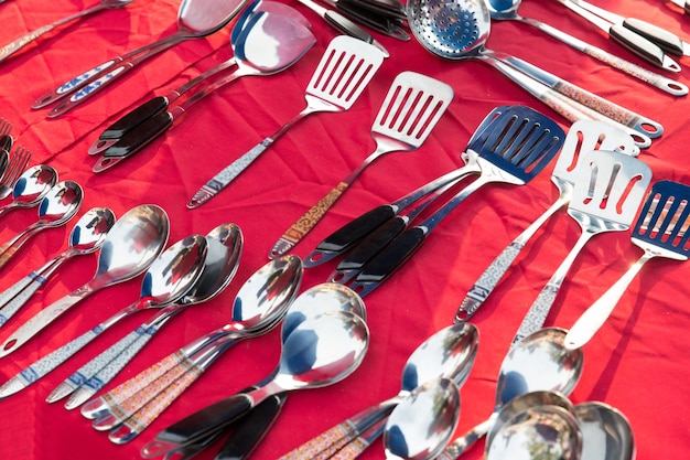 tableware and kitchenware concept - spoons and spatulas sale at street market