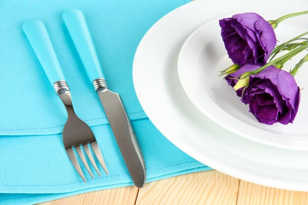 Tableware with flower on bright napkin closeup