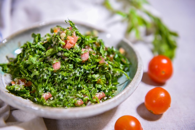 Taboule of tabouleh salade met tomatenui en komkommer geserveerd in schotel geïsoleerd op voedsel tafelblad weergave van kruiden uit het Midden-Oosten