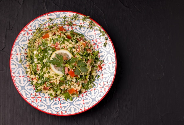 Tabule - insalata orientale, antipasto su uno sfondo nero.