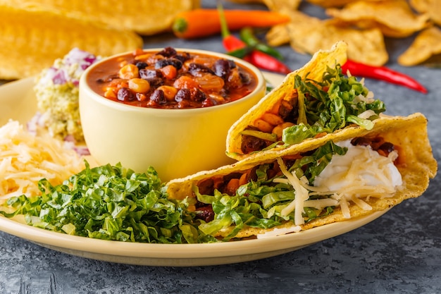 Taco's met chili con carne, salade, kaas en zure room, selectieve aandacht.