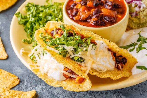 Taco's met chili con carne, salade, kaas en zure room, selectieve aandacht.