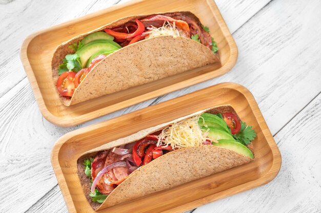 Foto taco's met ham en groenten op het houten serveerbord