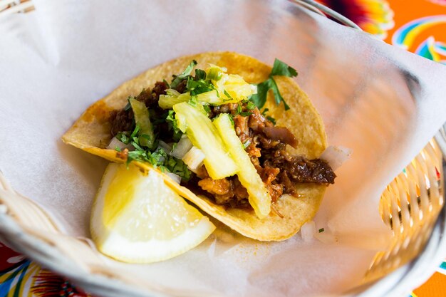 Taco van varkensvlees. Een taco is een traditioneel Mexicaans gerecht dat bestaat uit een kleine maïstortilla ter grootte van een hand.