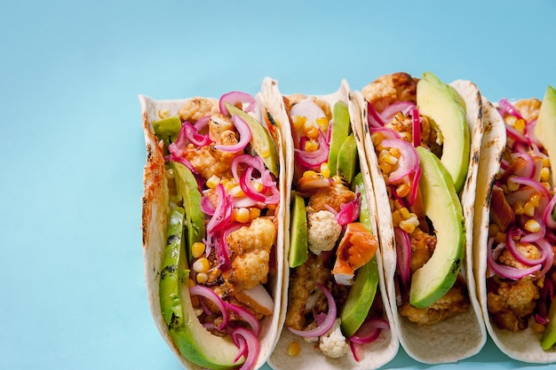 Tacos with avocado cauliflower corn on a blue background