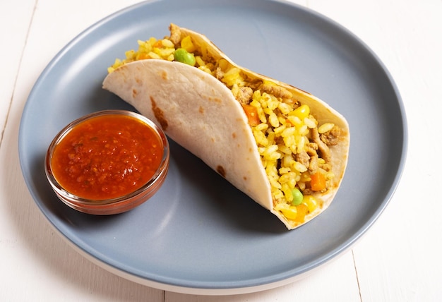 Foto tacos con salsa di pomodoro piccante su un piatto blu