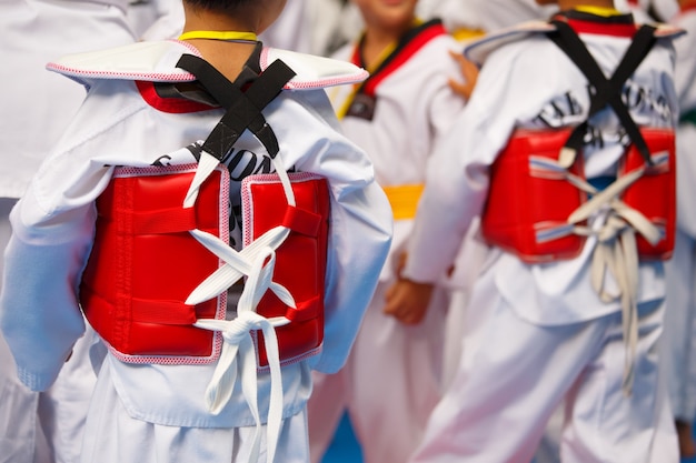 Taekwondo-atleten met uniform en rood pantser