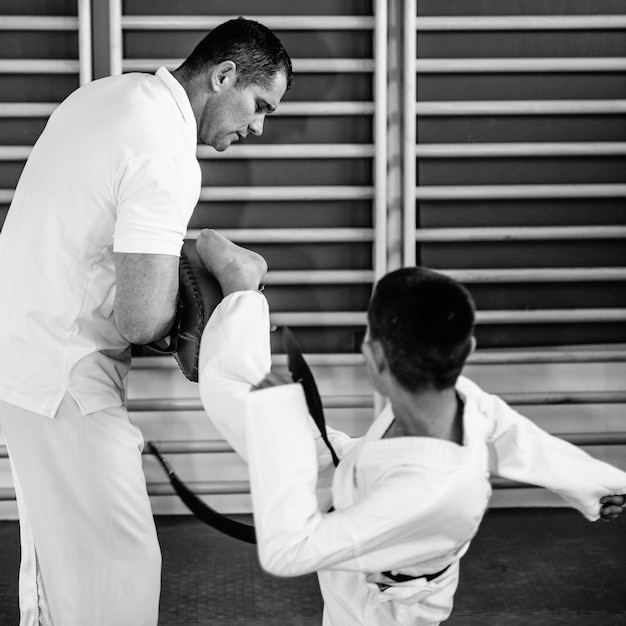 Photo taekwondo instructor working with boy